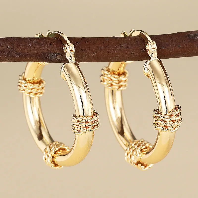 Geometric copper earrings with gold tone finish showing ring and line design elements