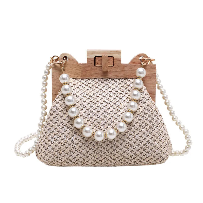 Women's straw woven shoulder bag with pearl chain detail showing internal organisation compartments