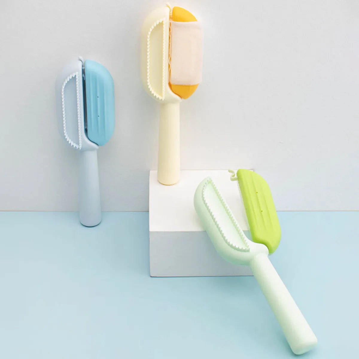 Blue pet grooming comb with water tank for dogs and cats on a white surface.