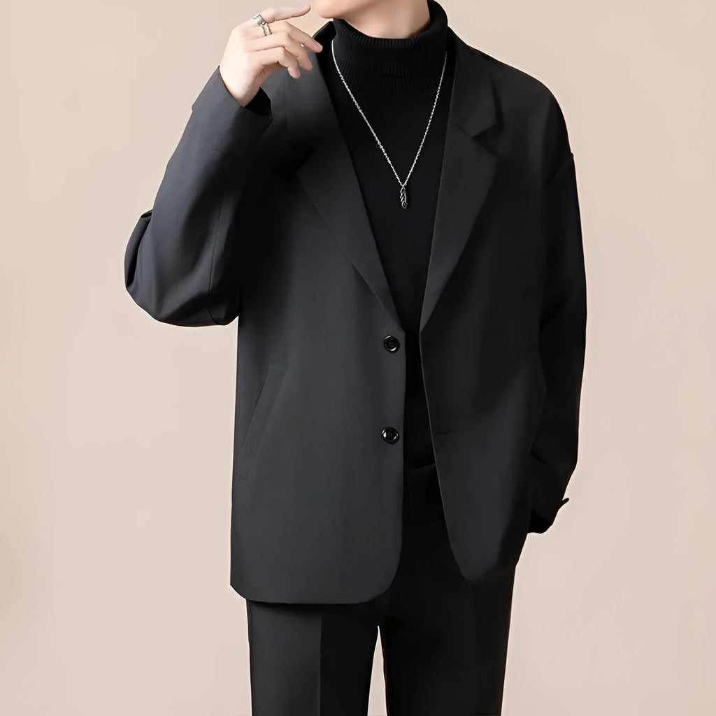 A man wearing a loose-fit casual suit jacket in a light colour, suitable for smart-casual occasions.