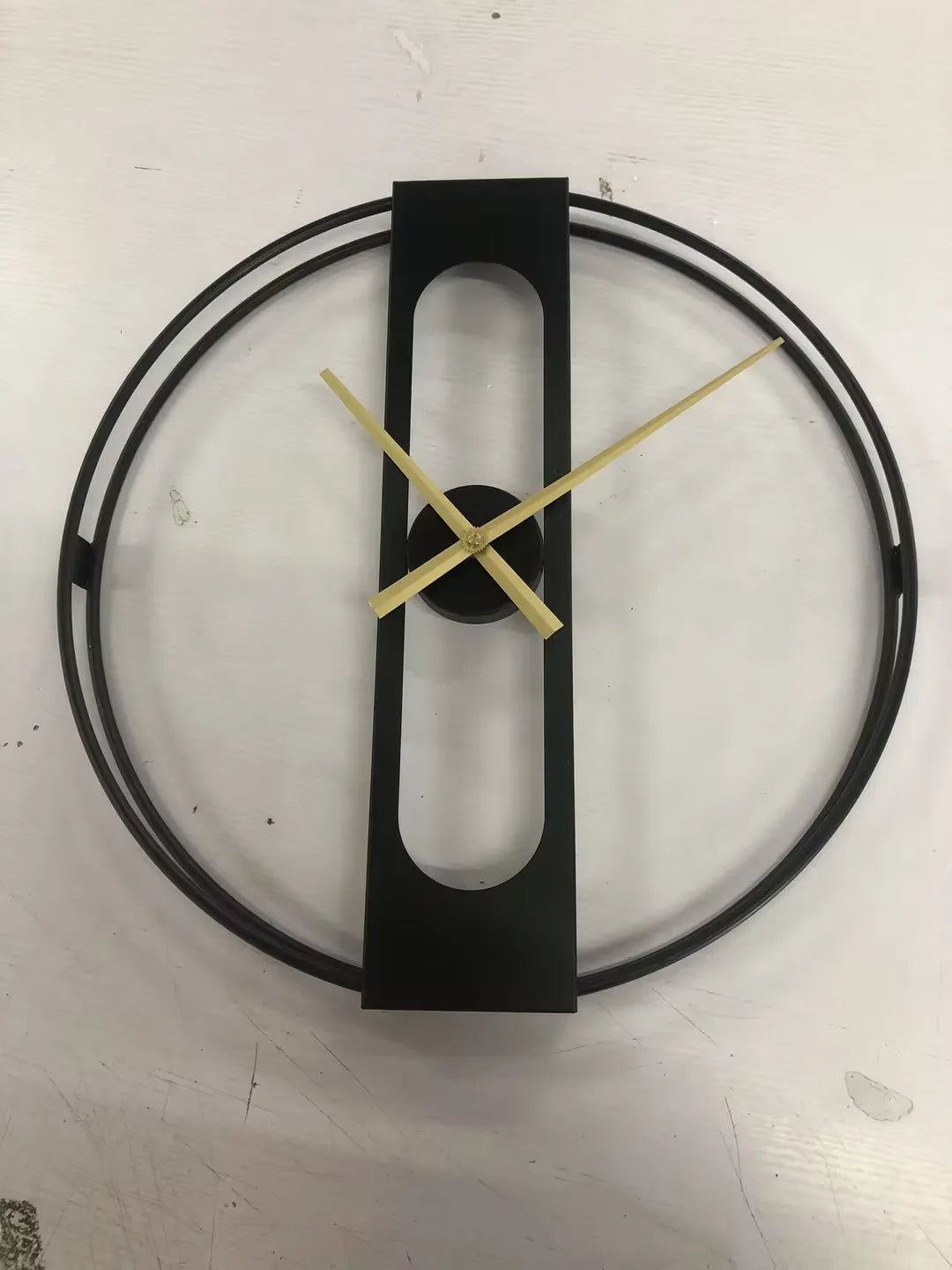 Large 50cm round metal wall clock in black or gold finish on a wall