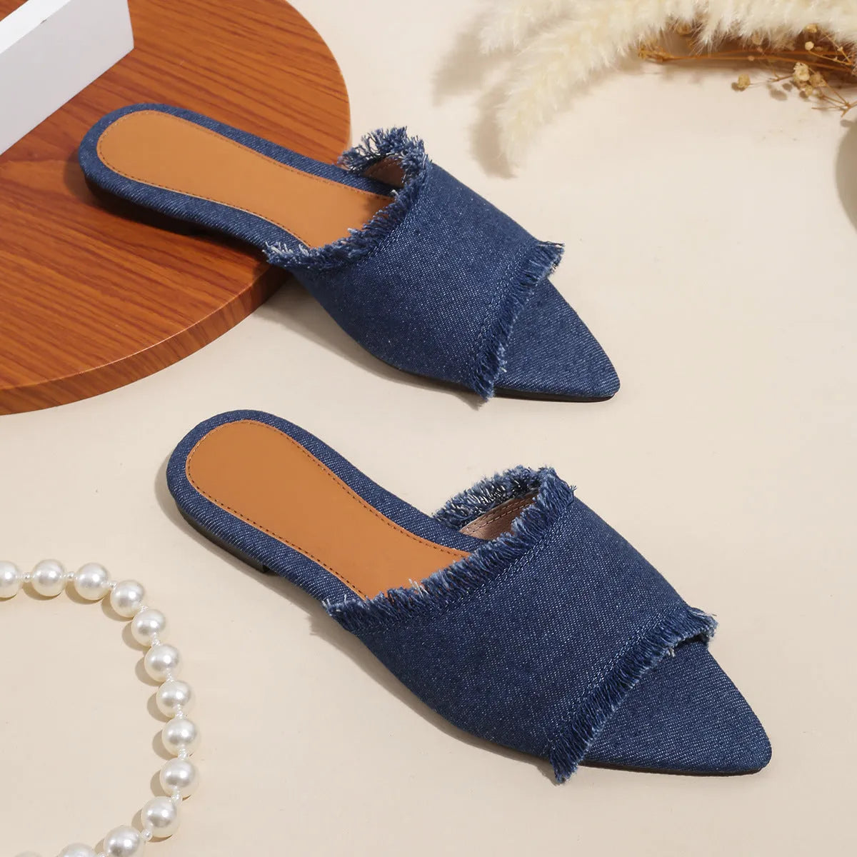 Women's flat denim slippers with tassel detail in apricot colour on a white background