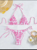 Women's pink floral halter neck swimsuit top and briefs set on a neutral background
