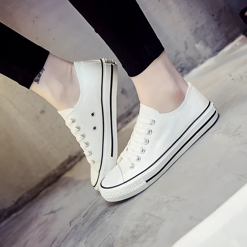 Women's solid-colour casual canvas shoes in black, white and black, white and red, or all black colourways.