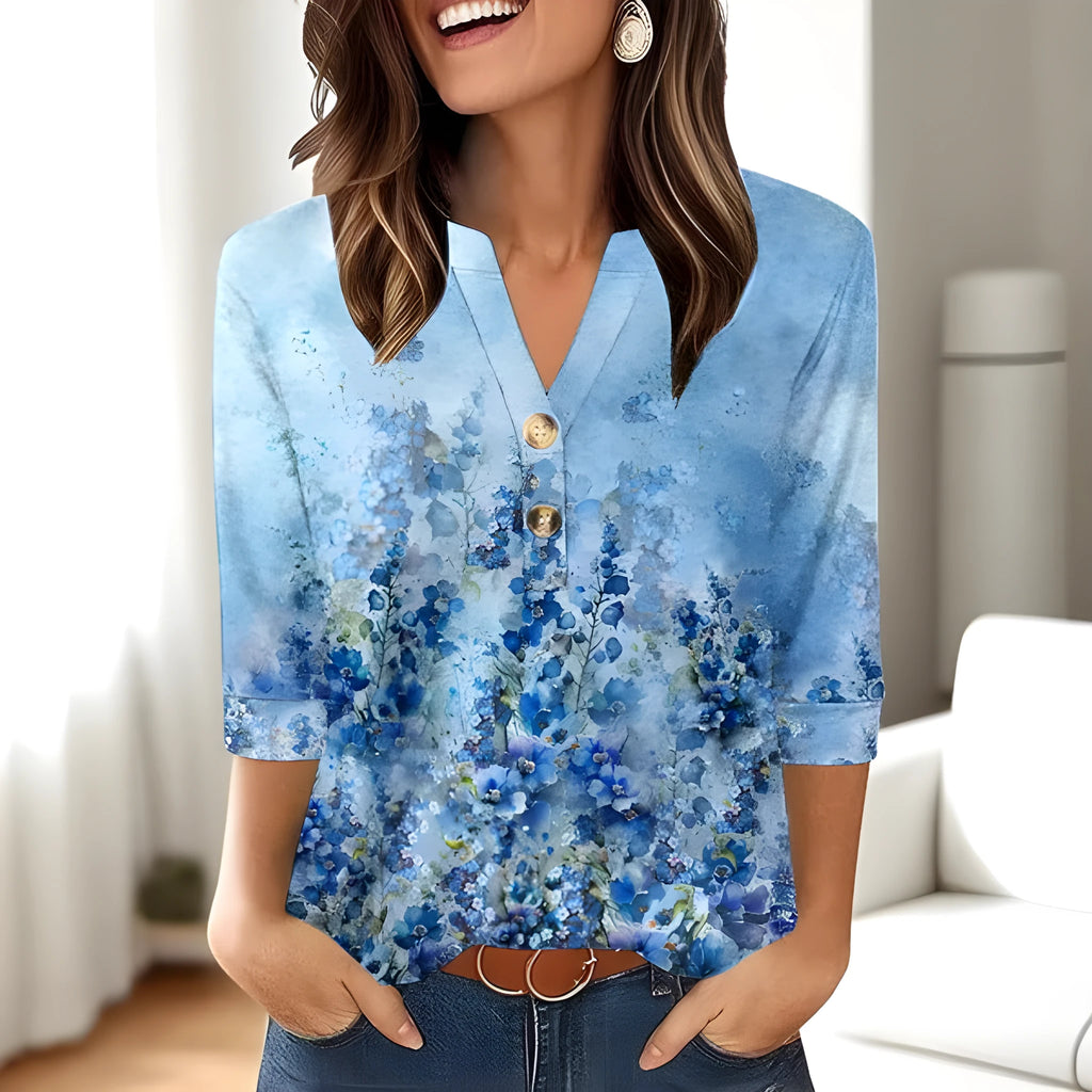 Woman wearing a loose V-neck T-shirt with a bold 3D pattern print in casual style.