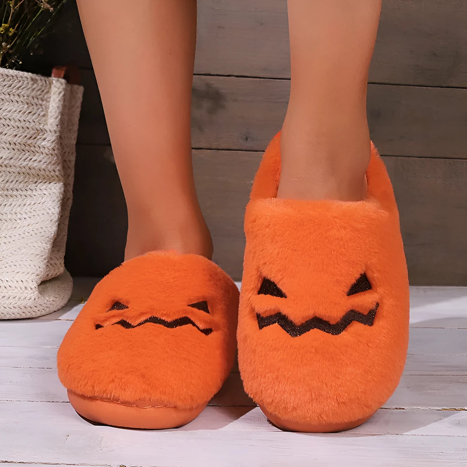 Orange Halloween pumpkin themed slippers with coral velvet upper and plush lining on a flat PVC sole.
