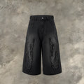 Men's black denim cropped shorts with red and yellow flame patch embroidery on the leg.