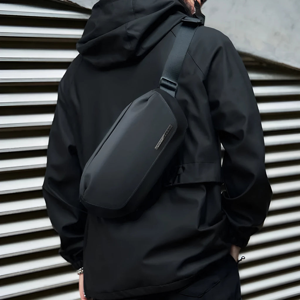 Black oxford cloth men's messenger bag with a cross-body strap.