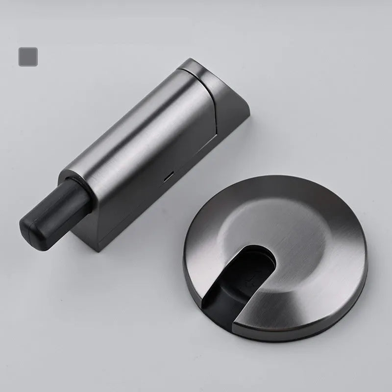 Modern zinc alloy invisible door stopper in brushed nickel finish on a wooden floor.
