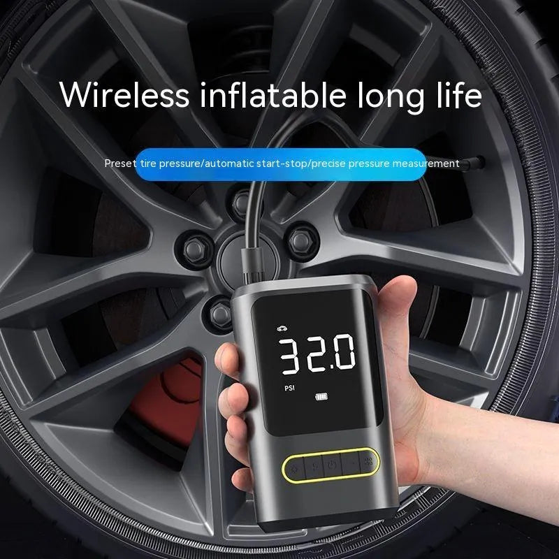 Black handheld digital wireless air pump with LED display and connected air hose on a grey background.