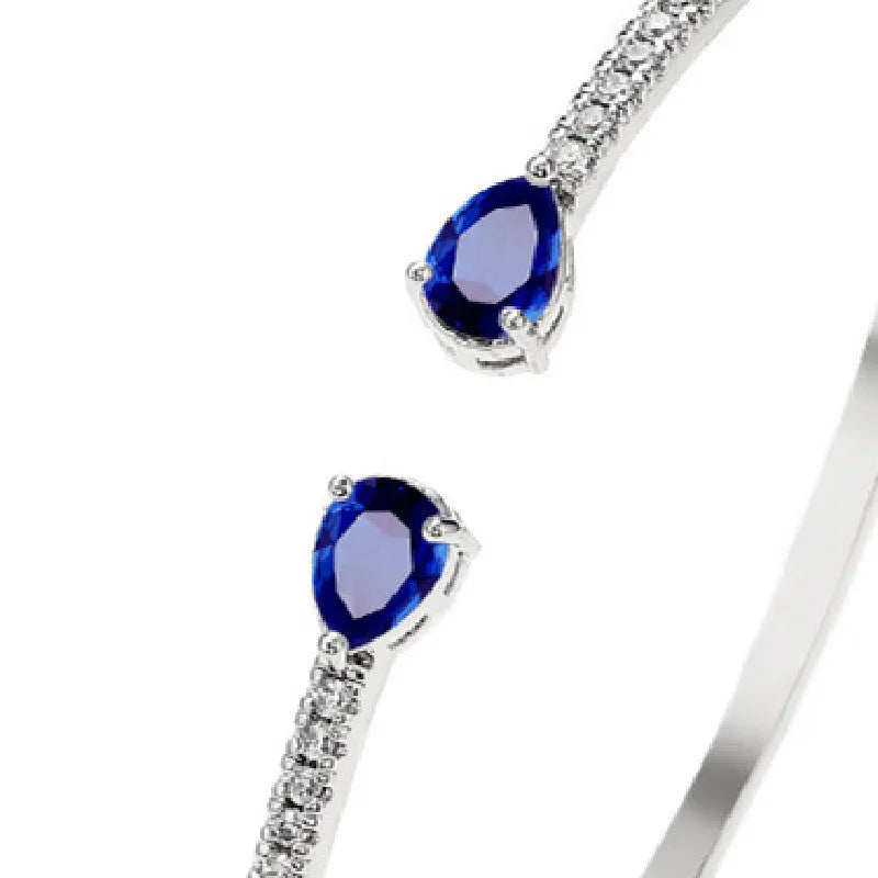 Copper fashion bracelet with inlaid white or blue zircon stones on a simple band.