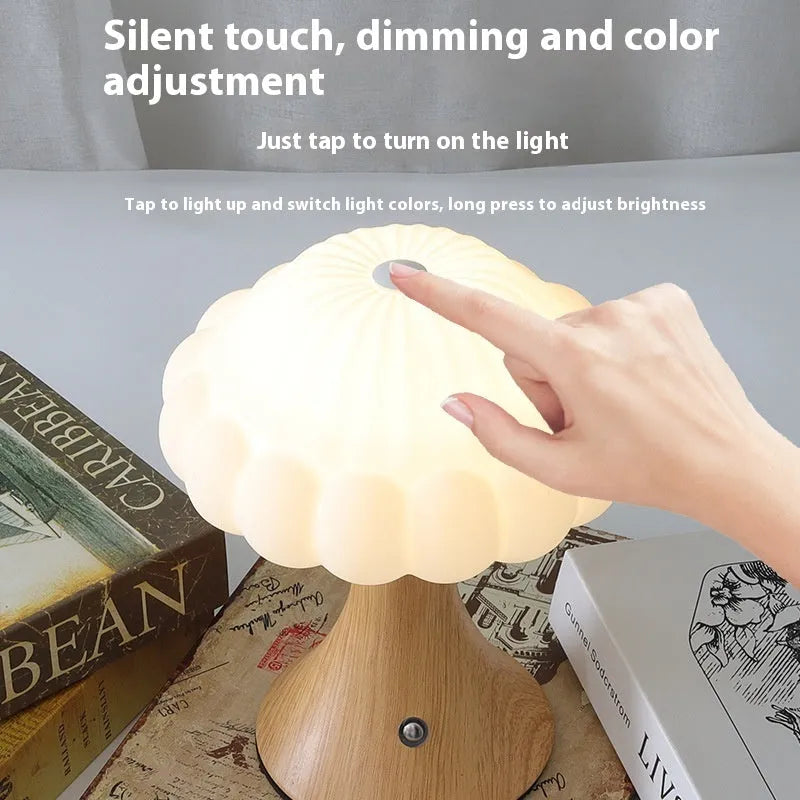 Small touch control rechargeable mushroom night light in wood grain colour on a table.