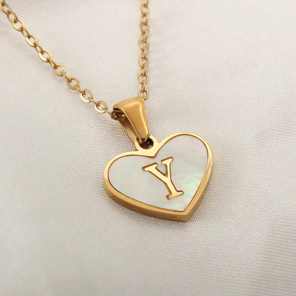 Gold plated heart-shaped personalised necklace with white shell charm on an adjustable chain.