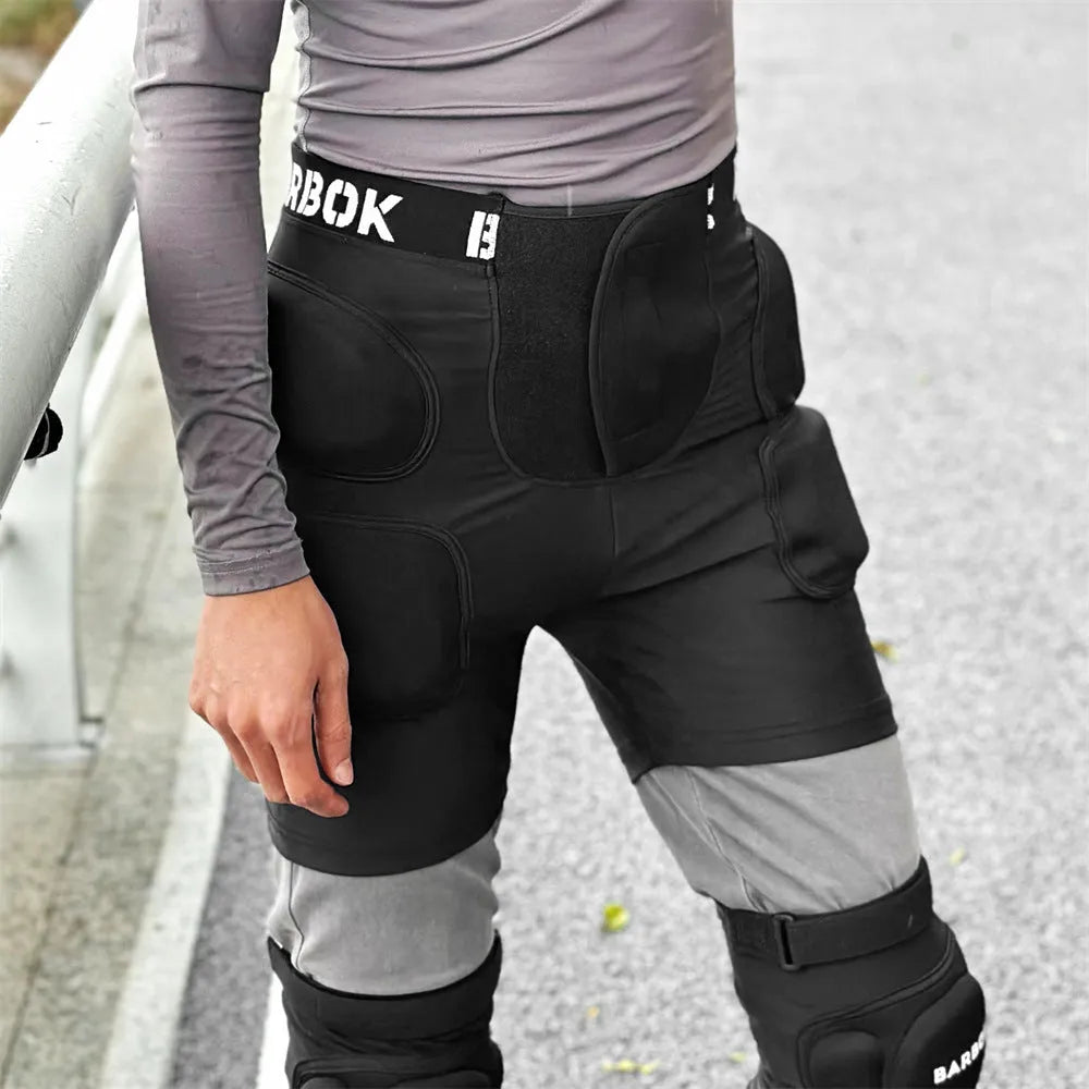 Black protective spandex trousers with integrated hip pads for skating and skateboard fall protection.