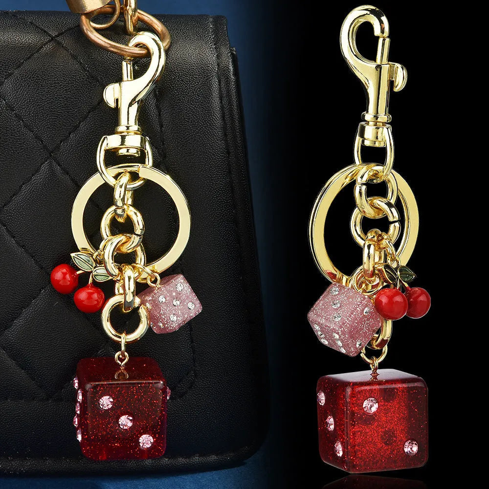 Vintage cherry red two-tone dice pendant on a metal keychain, a retro suitcase ornament.