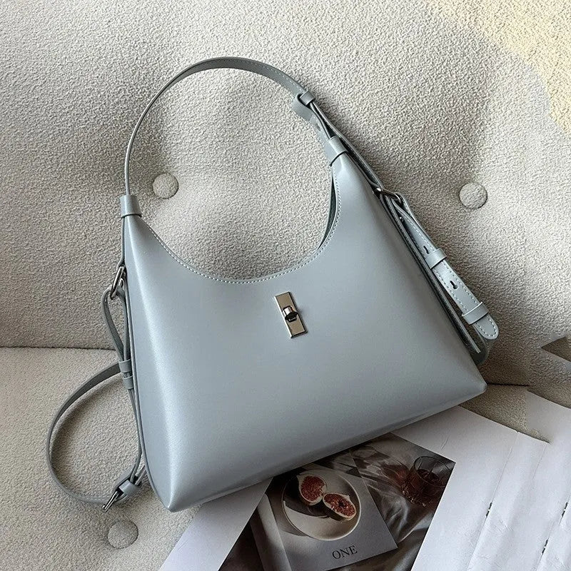 A soft genuine leather dumpling-shaped crossbody shoulder bag in a street style, shown with internal phone pocket.