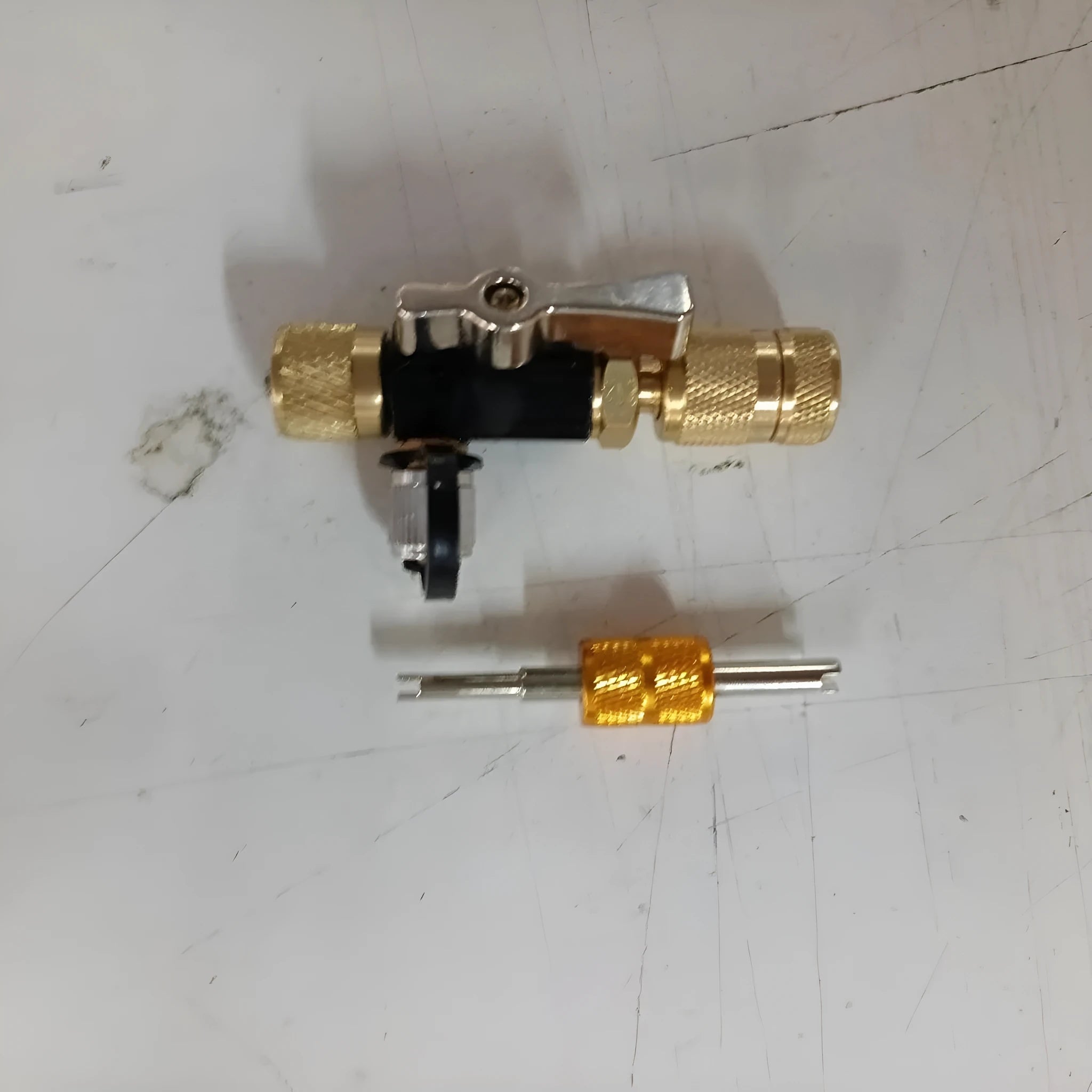 Metal valve core disassembly tool set showing black and pink valve removers and a valve core wrench.
