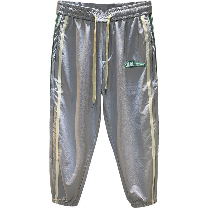 A man wearing grey cotton harem pants with a relaxed fit and elasticated mid-waist.
