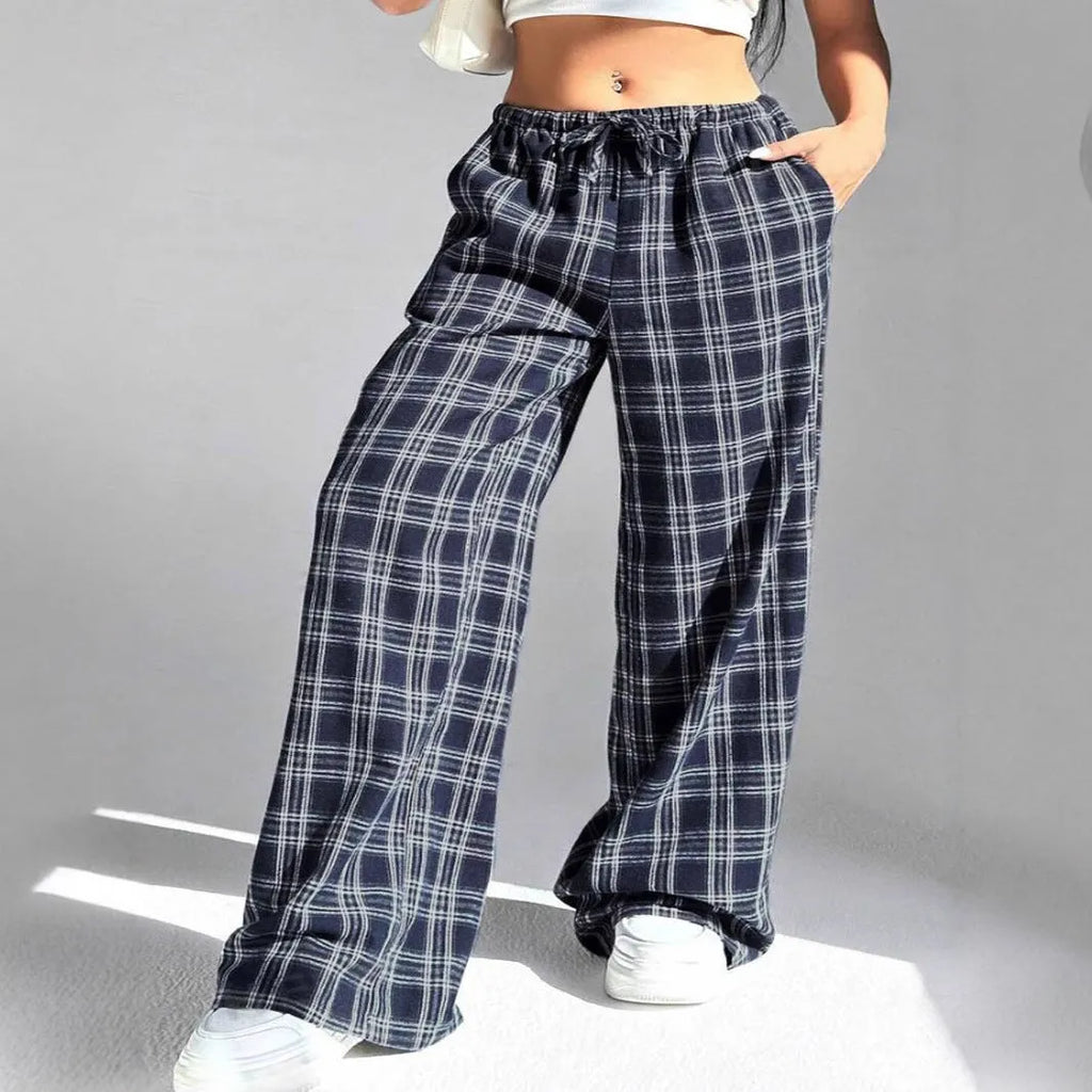Red women's loose fit plaid trousers with drawstring waist and pockets on a mannequin.