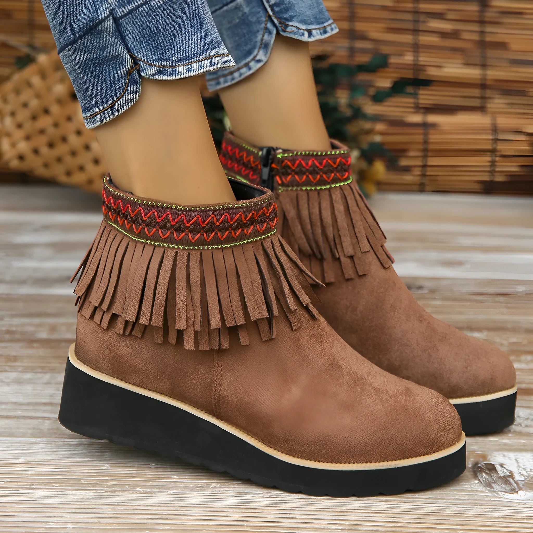 Women's black suede wedge ankle boots with side zip, tassel, and thick rubber sole.