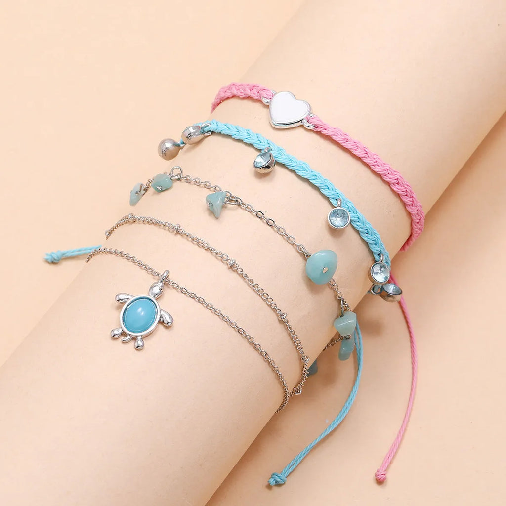 Hand-woven blue love foot rope natural gravel anklet in alloy with geometric shape on a woman's ankle