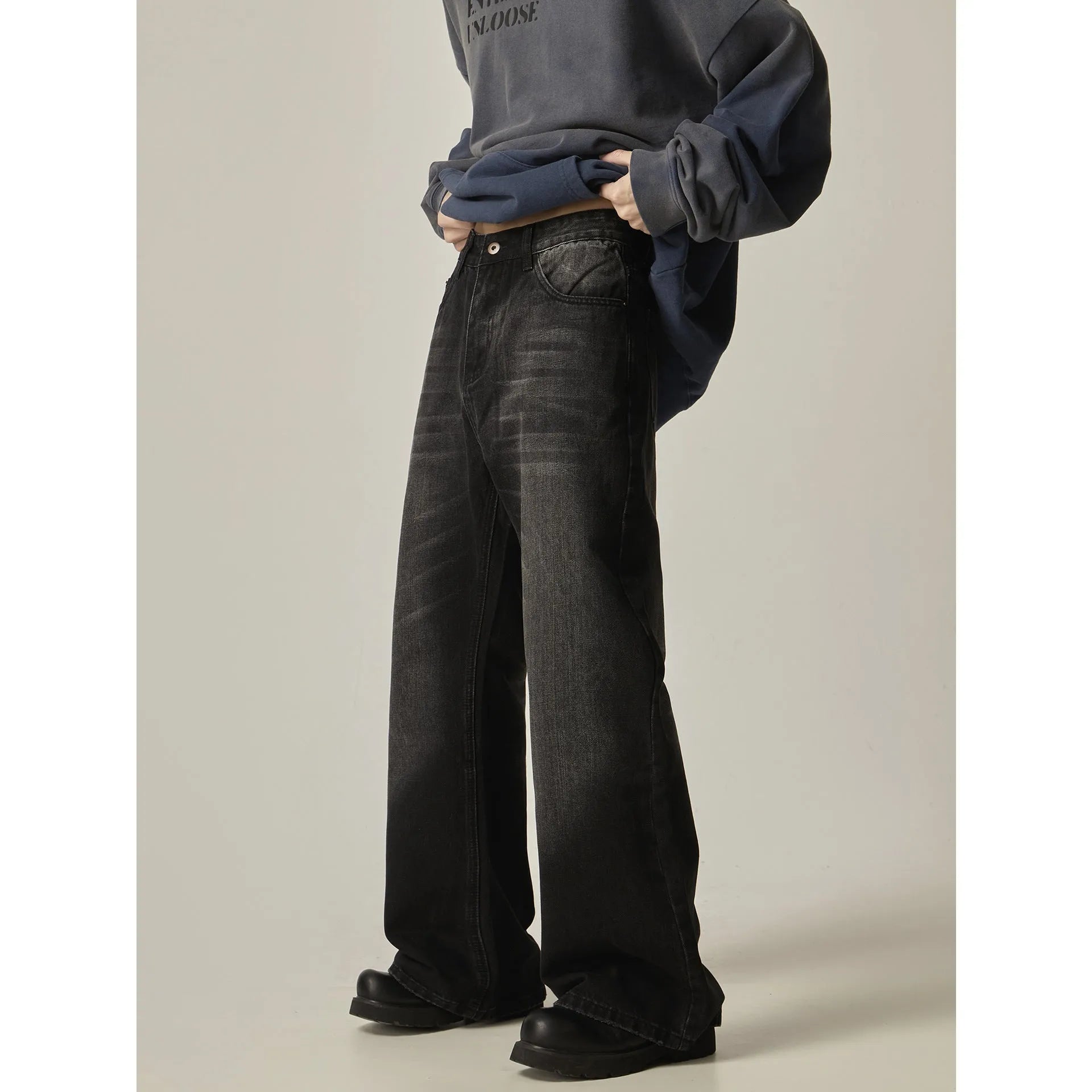 Man wearing black loose-fit straight-leg retro jeans in a casual setting.