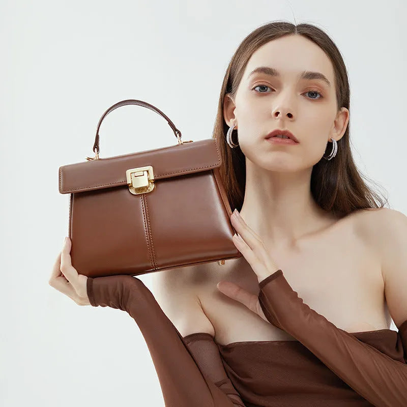 Women's black genuine leather shoulder bag with vachette clasp closure showing horizontal square design