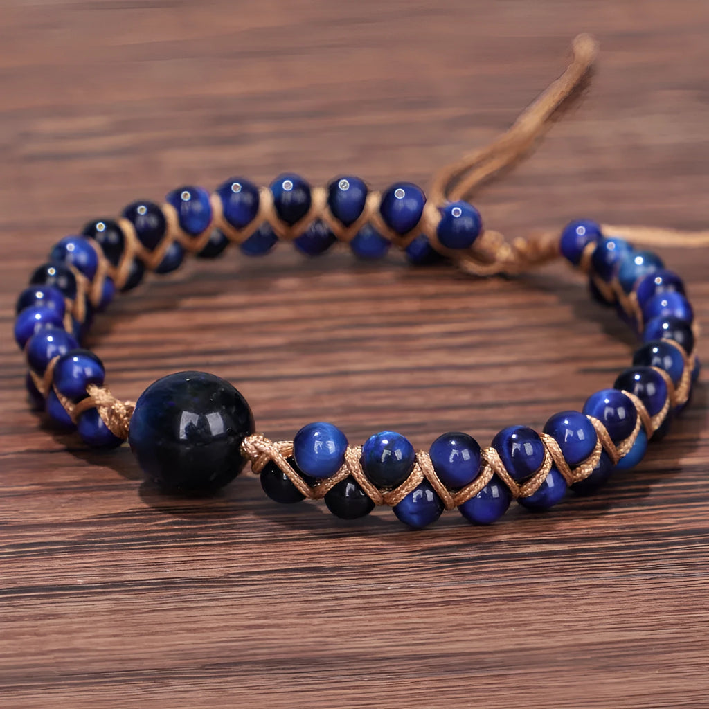 Handmade woven geometric bracelet with blue tigereye stone beads and adjustable pull closure.