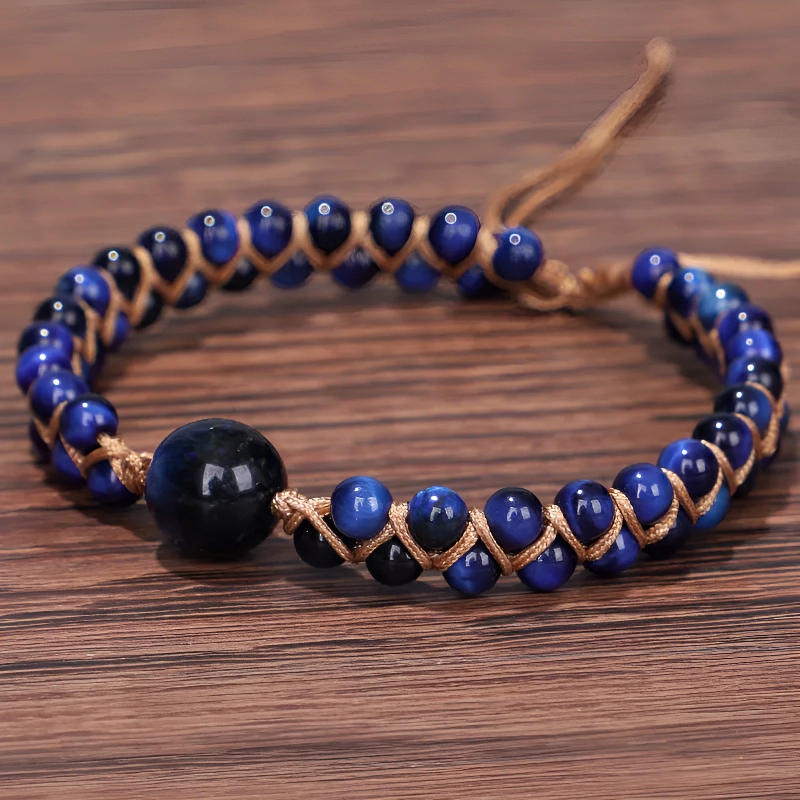 Handmade woven geometric bracelet with blue tigereye stone beads and adjustable pull closure.