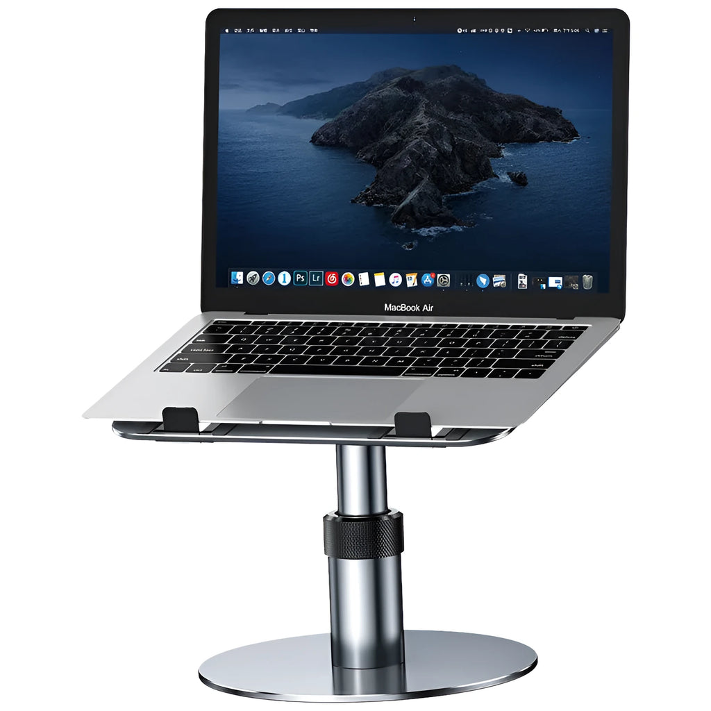 Silver adjustable aluminum laptop stand with non-slip pads on a desk next to a laptop.