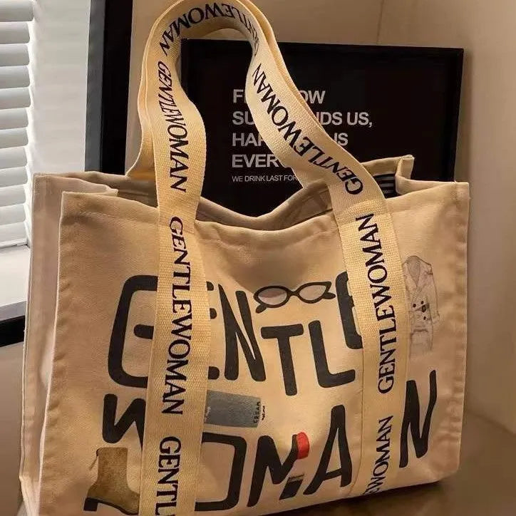 Large canvas women's travel tote bag with print design options including black letters and patterns.