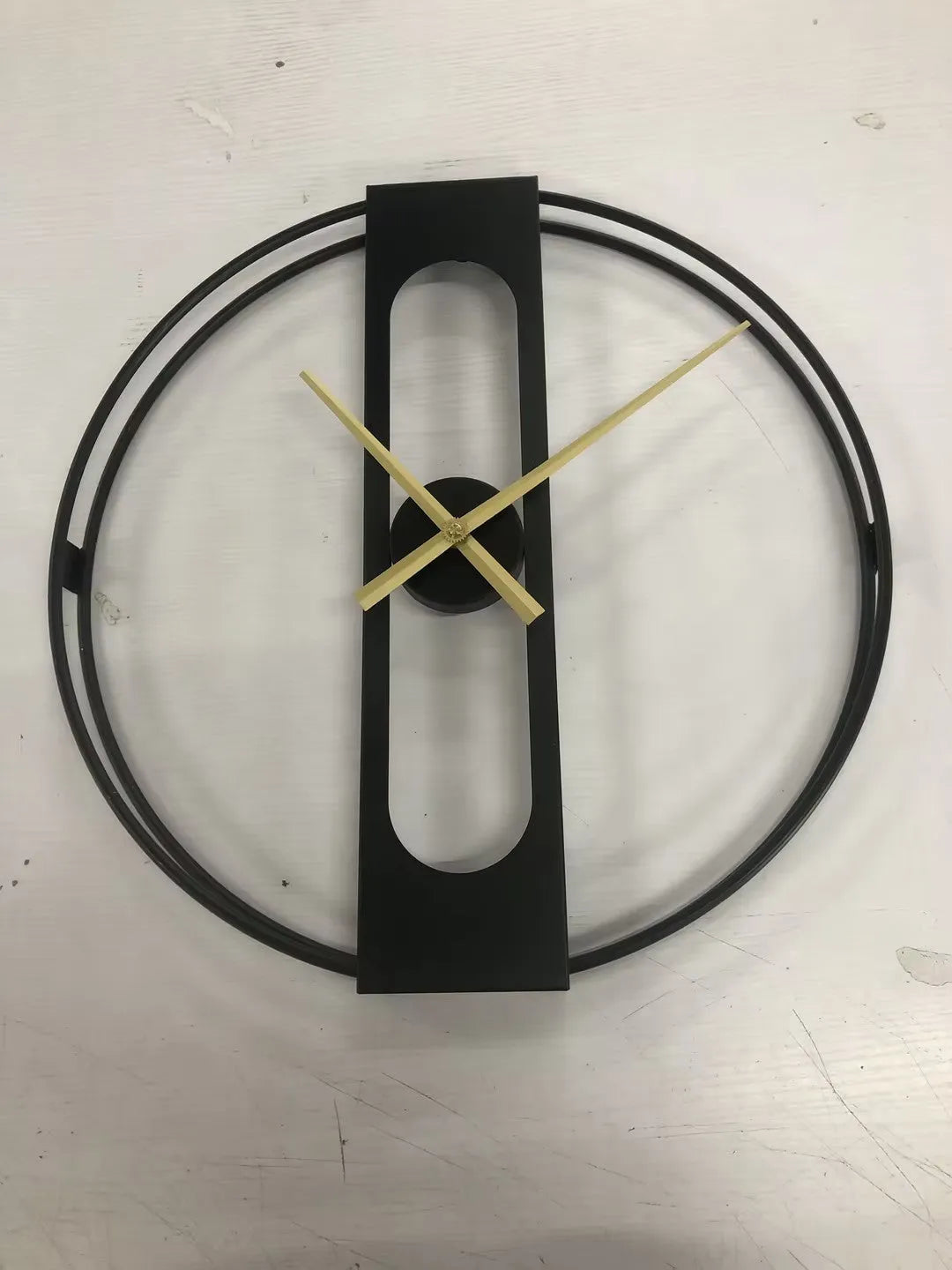 Large 50cm round metal wall clock in black or gold finish on a wall
