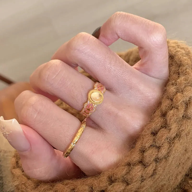 Women's geometric open ring with pink crystal enamel detail on gold-plated copper.