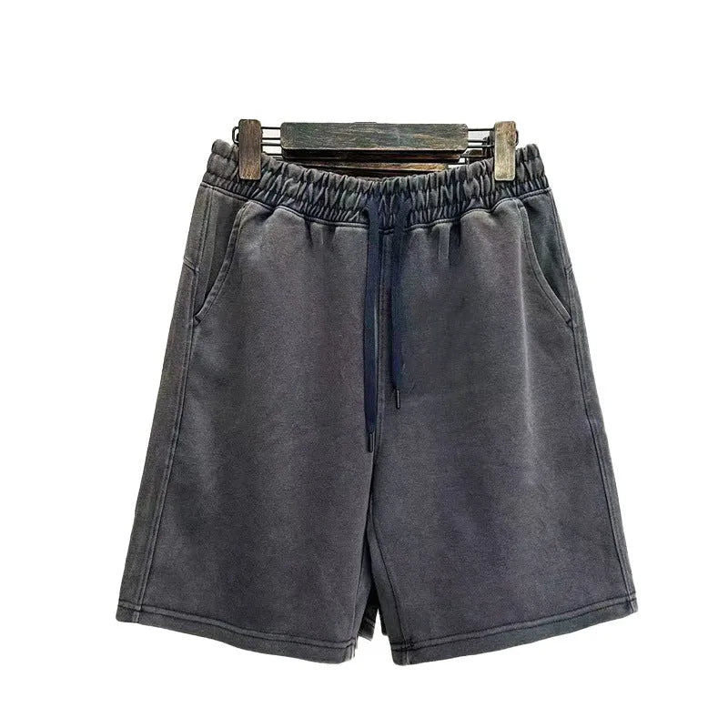 Men's light blue cotton shorts with distressed detailing and a loose, straight-leg fit on a mannequin.
