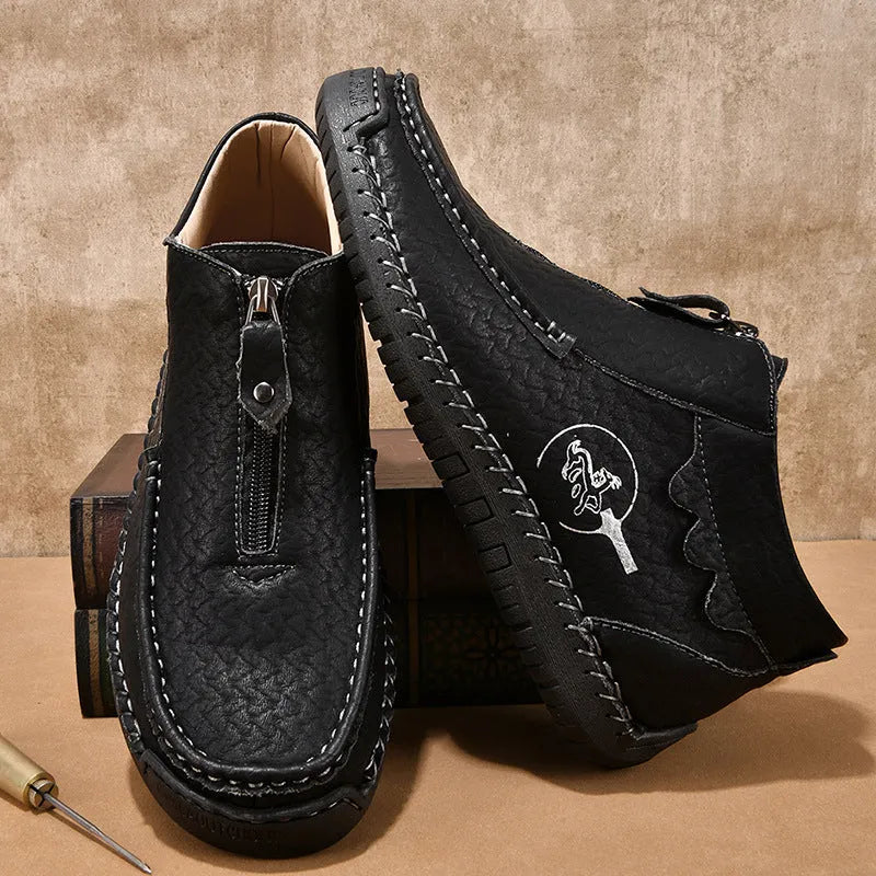 Men's black slip-on leather loafers with round toe and stitching detail on a solid colour background.