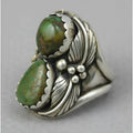 Silver-toned geometric women's ring with a turquoise stone inlay, shown on a finger.