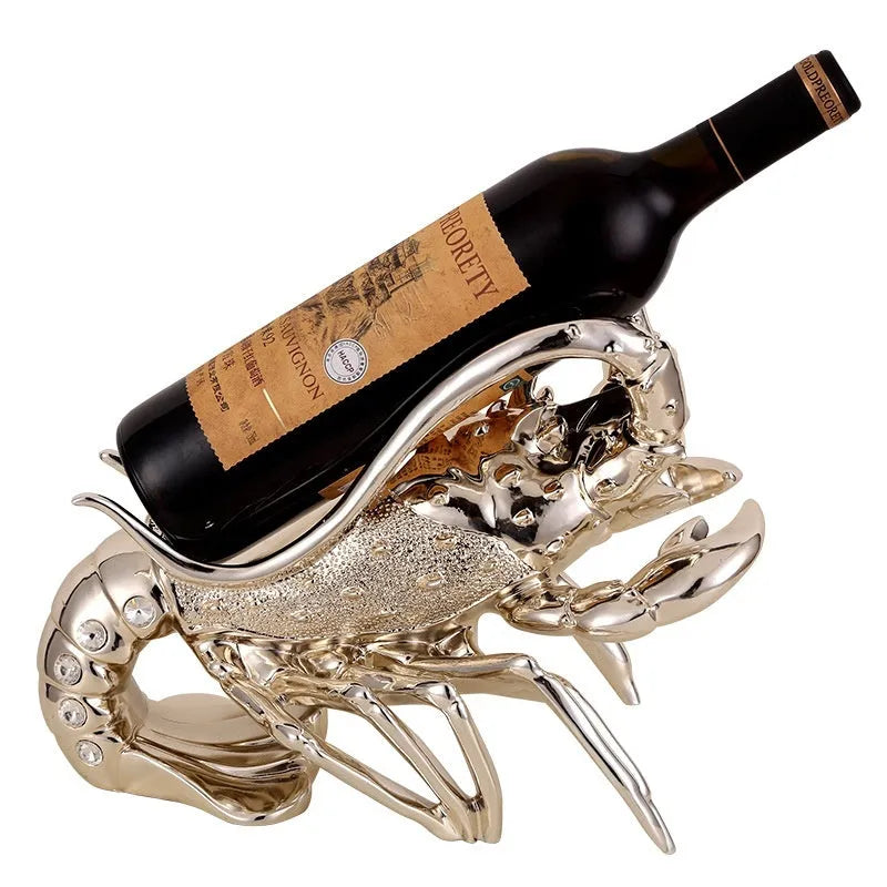 Rose gold resin lobster ornament holding a wine bottle on a wooden shelf.
