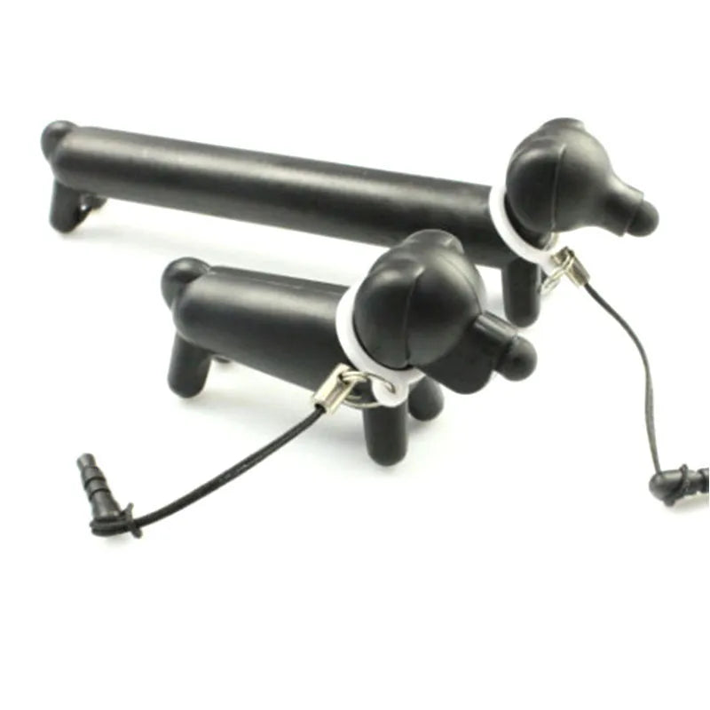 Black dog-shaped touch screen stylus with conductive body shown next to smartphone demonstrating phone holder function