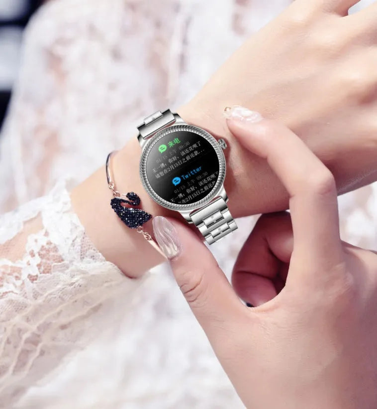 AK38 ladies smart watch with stainless steel Milanese band and 1.09-inch colour screen displayed on a wrist.