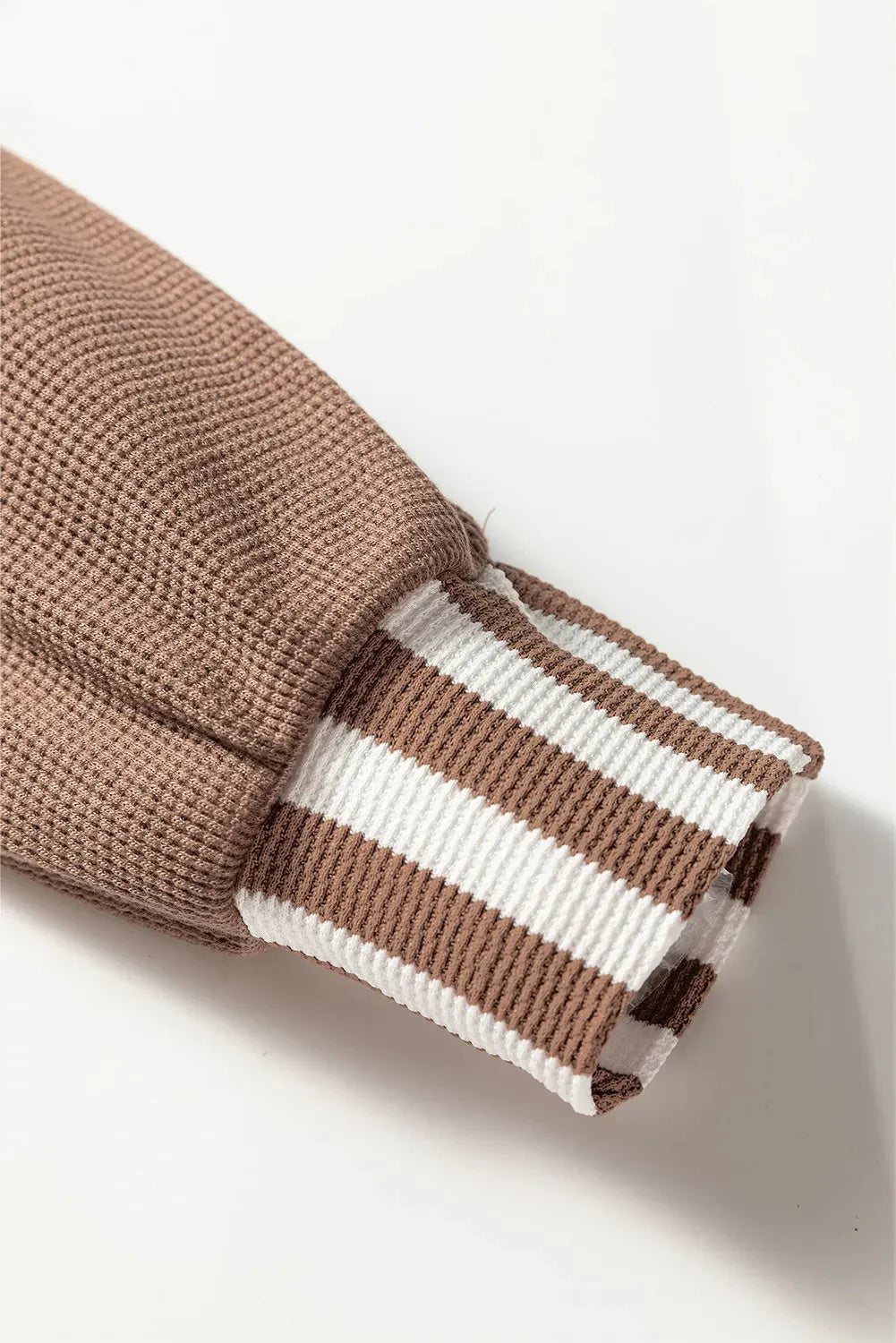 Straw yellow hoodie with waffle texture and striped patchwork design featuring drawstring hood and button neck closure