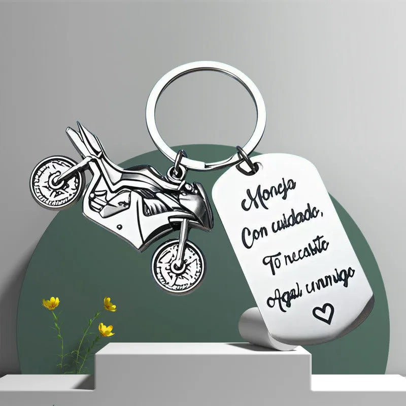 Stainless steel motorcycle keychain with a modern minimalist design, shown with a velvet flannel bag.