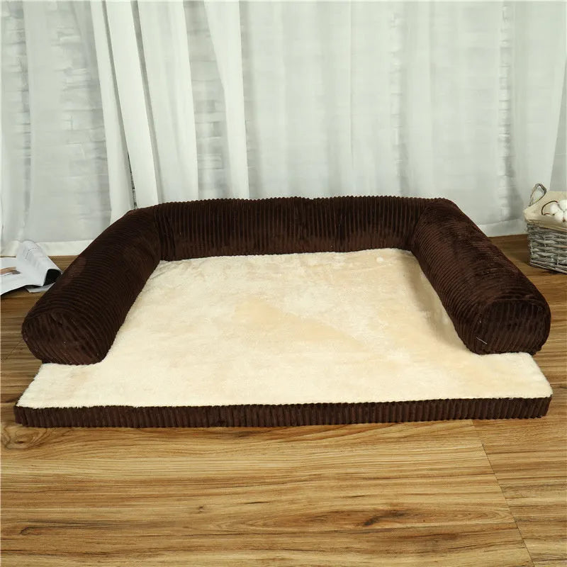 A corduroy pet sofa dog bed with a raised bolster, shown in a grey colour on a wooden floor.