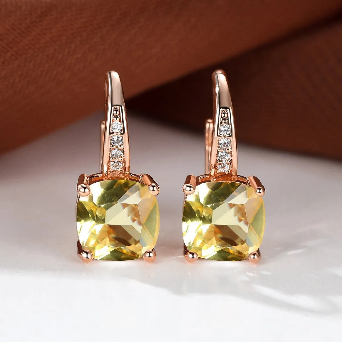 Square geometric ear hook earrings with zircon stones in an electroplated copper setting.