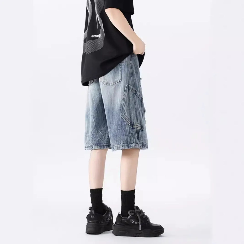 Loose fit ripped denim shorts in black and blue washes on a size chart