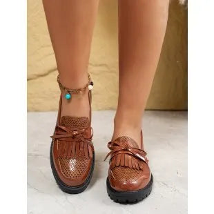 Women's brown and black loafer shoes with decorative bow detailing