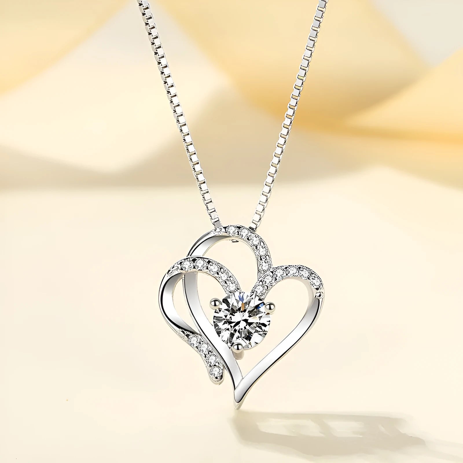 Close-up of a women's heart-shaped pendant necklace in 925 silver with a choice of gold tone finishes.