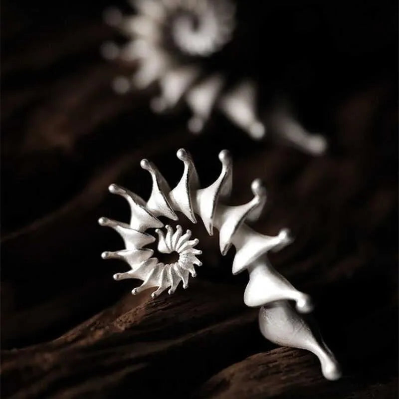 Conch ear studs with exaggerated three-dimensional matte finish and irregular geometric shape