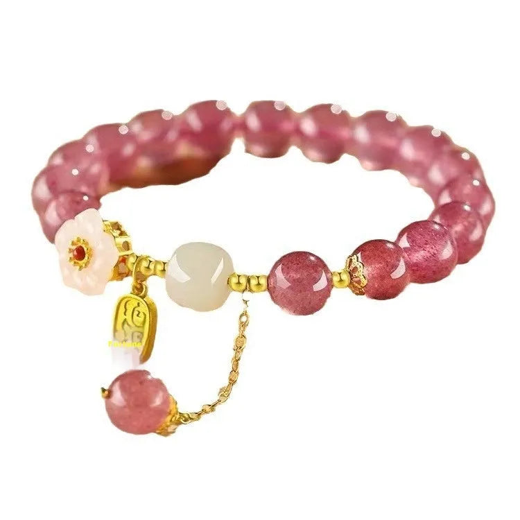 Handcrafted strawberry quartz crystal bracelet with peach blossom design on wrist