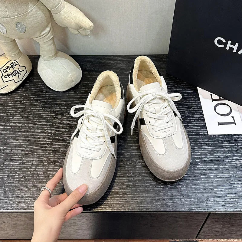 Women's beige distressed leather lace-up sneakers with round toe and rubber sole on a neutral background.
