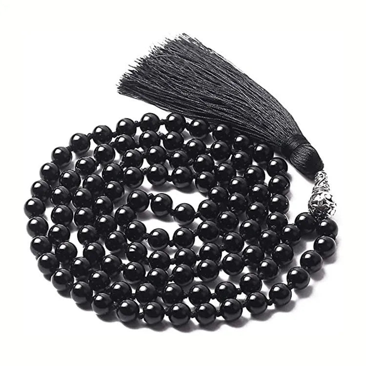 Long agate tassel necklace with geometric stone beads in various colours on a neutral background.